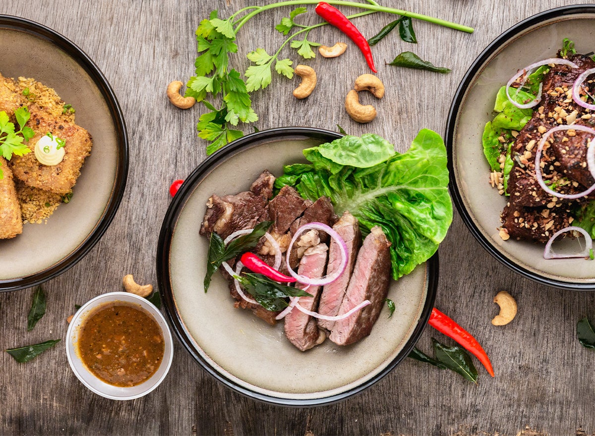 Three delicious looking dishes with a steak bowl in the middle