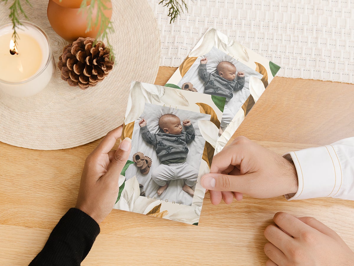 Hands holding Artifact Uprising Holiday Cards featuring baby photo