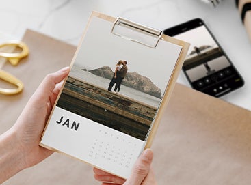 Hands holding photo calendar that is about to be gift wrapped
