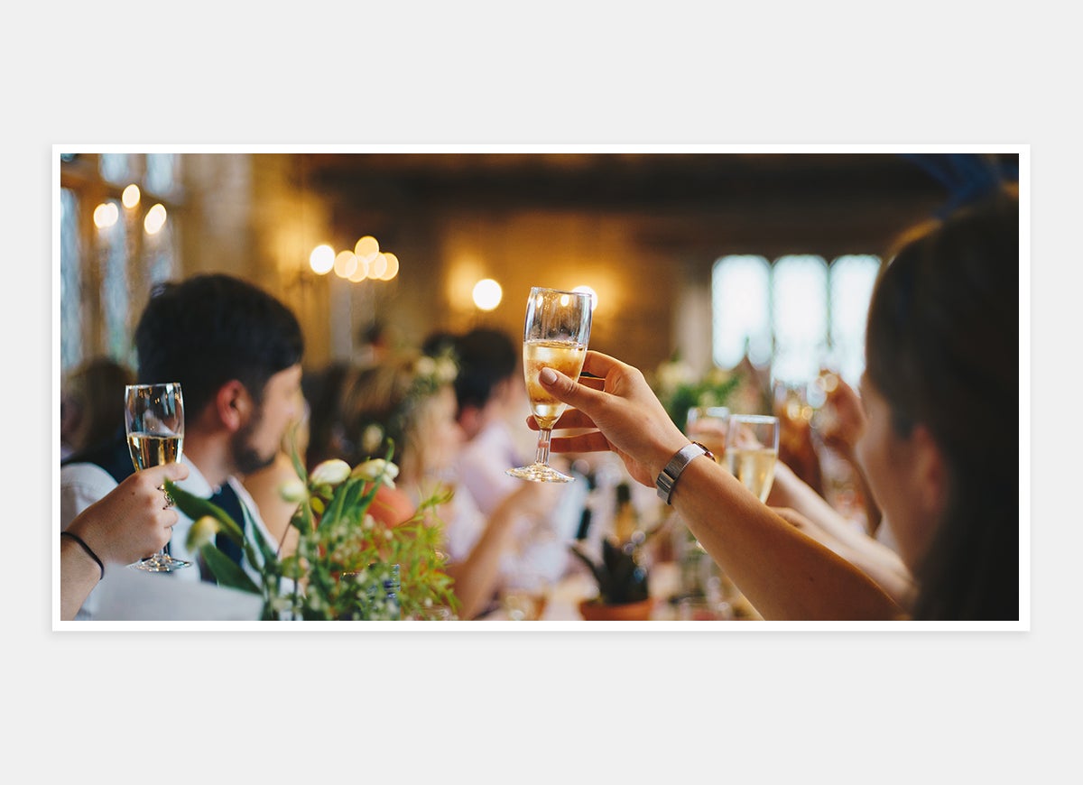Two-page photo in wedding album of hands toasting champagne