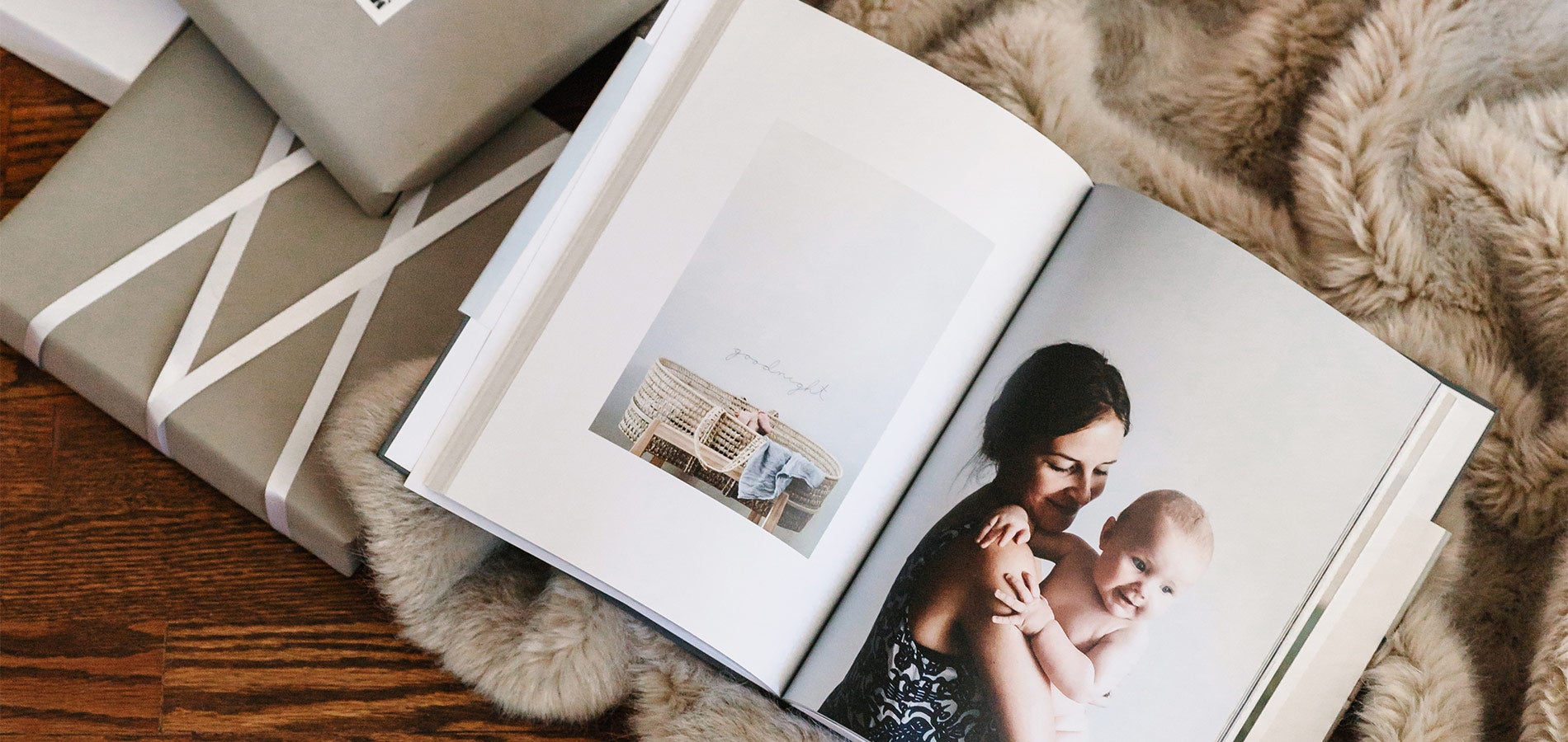 gift boxes next to photo book featuring full page image of mother and baby
