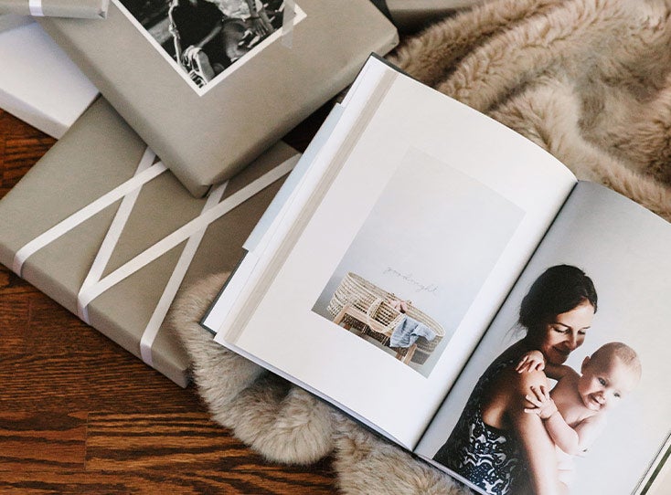 wrapped gifts next to photo book opened to full page image of mother and baby