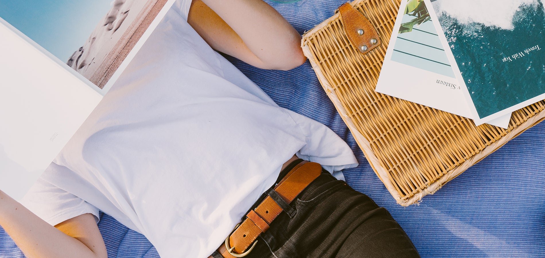Woman laying on picnic blanket reading softcover photo book