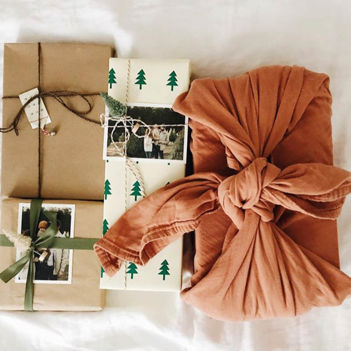 Three traditionally-wrapped gifts next to gift wrapped in tea towel