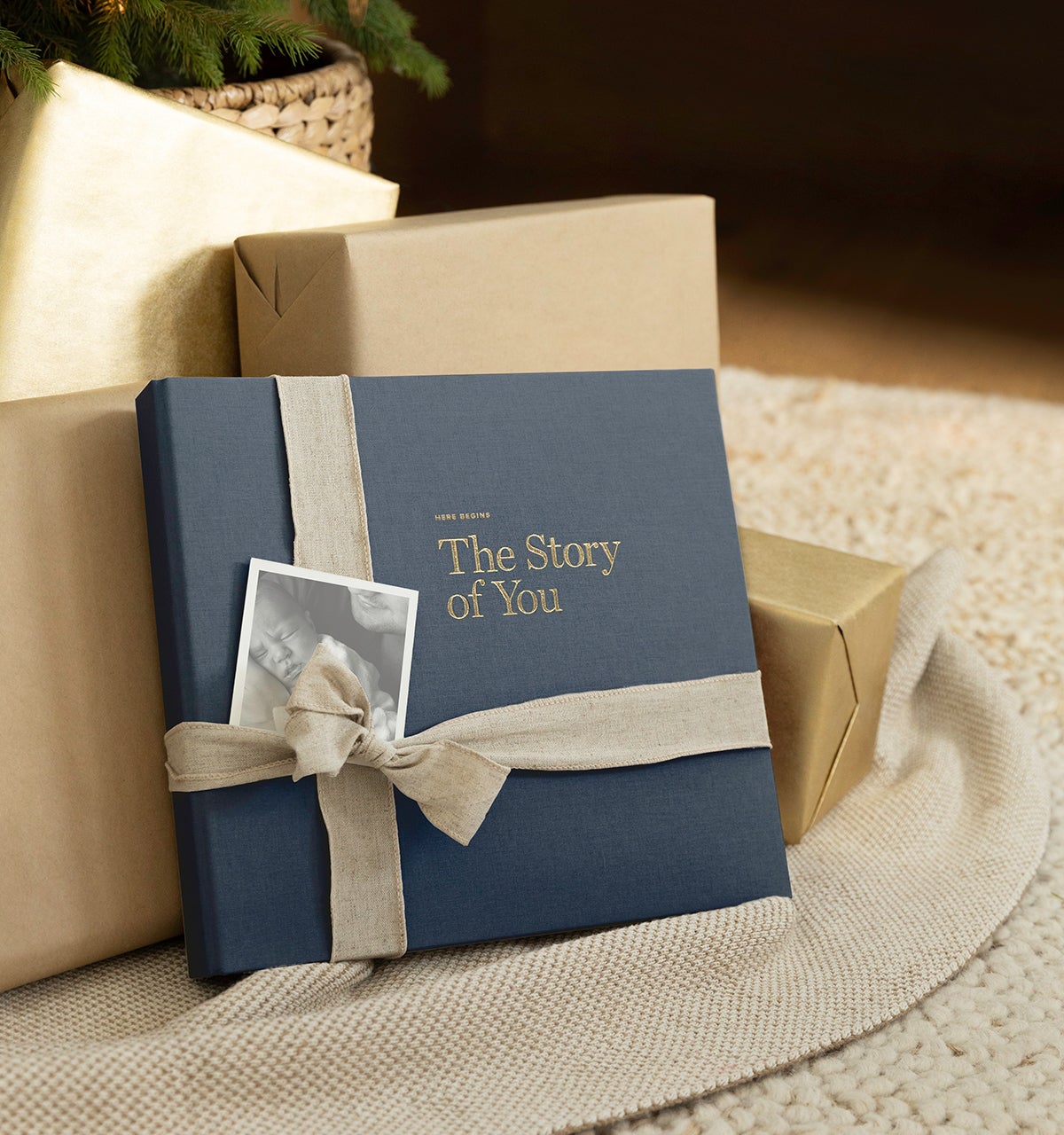 Artifact Uprising Story of You Baby Book wrapped with ribbon next to wrapped gifts
