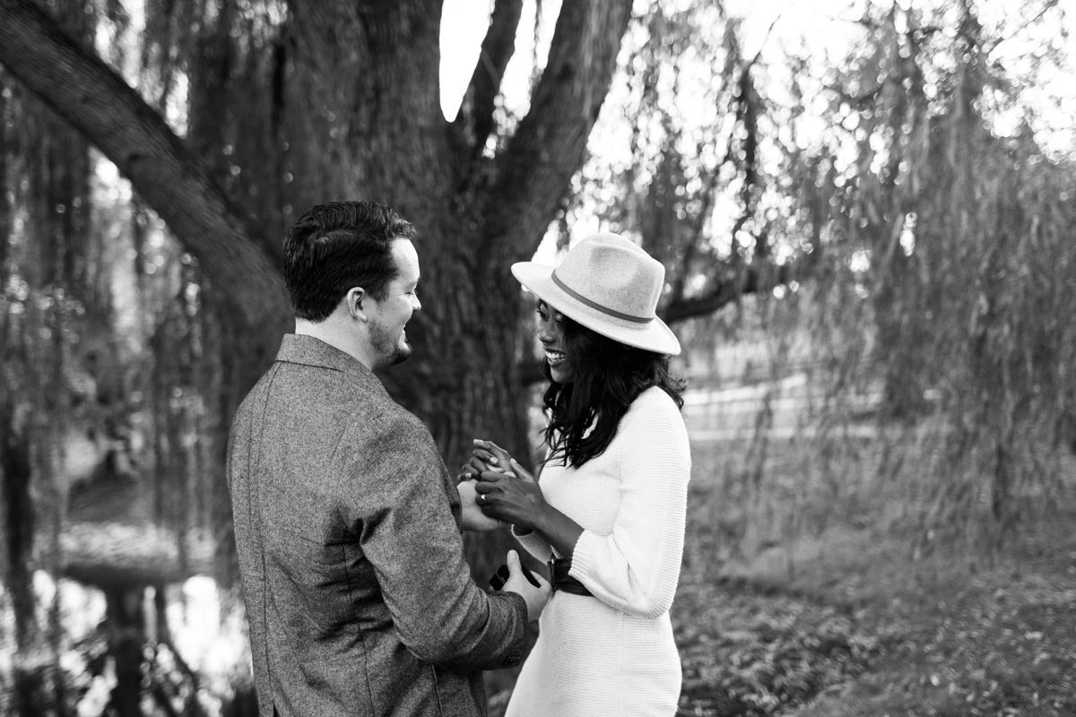 Photo of couple laughing in front of weeping willow