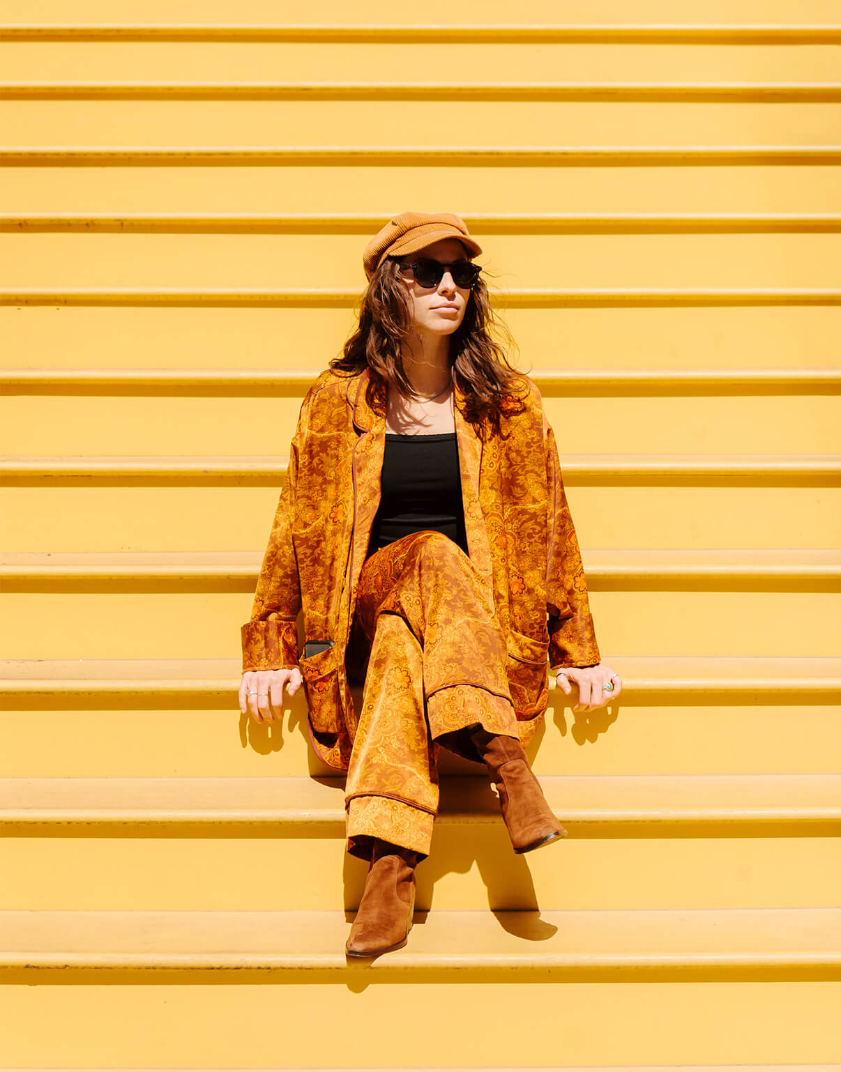 Photo by Brandon Lopez of velvet-clad woman sitting on endless yellow stairs