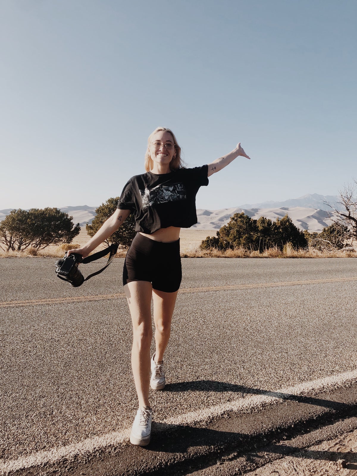 Molly Olwig walking across remote highway with camera