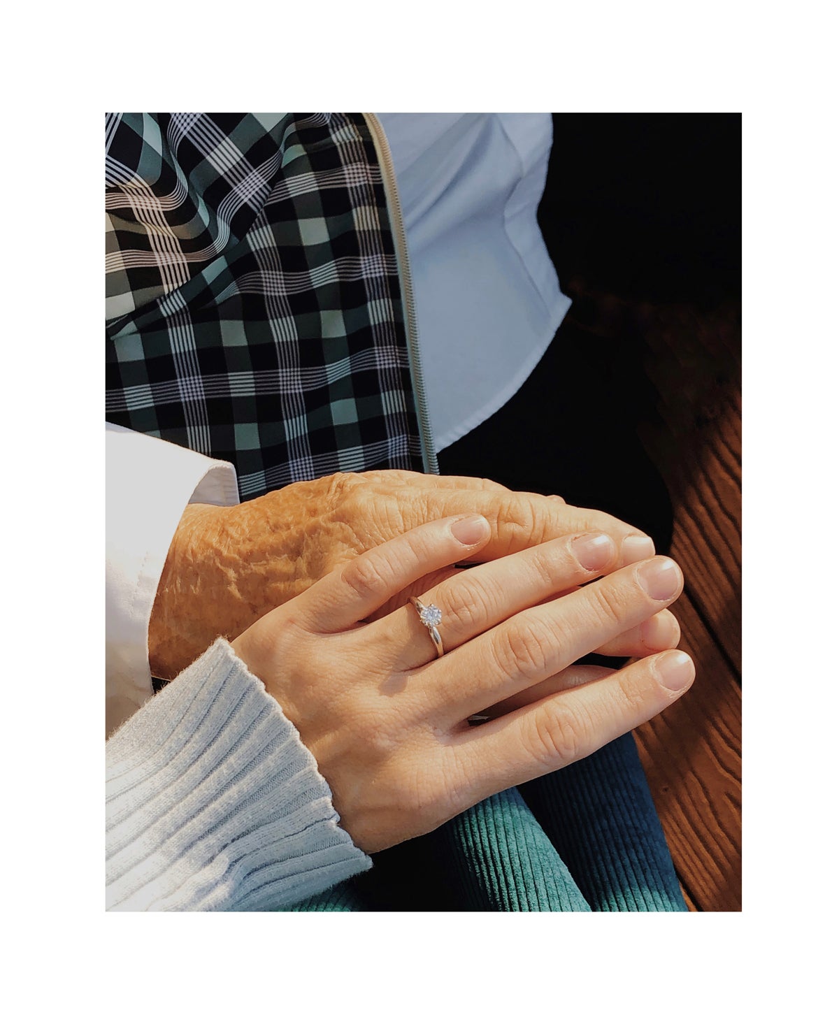 Photo by Molly Lopez of hand with ring resting on hand of parent
