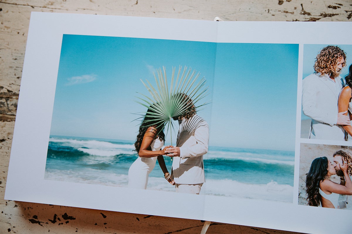 Signature Layflat Album opened to posed photos of bride and groom on the beach