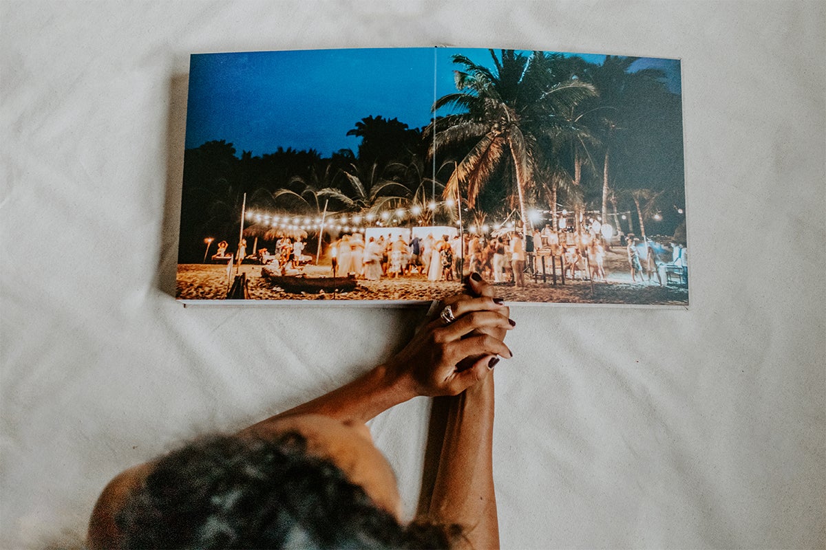Signature Layflat Album opened to two-page panoramic image of reception on the beach at night