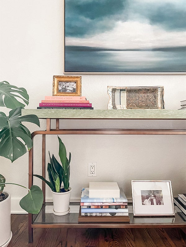 Console Table filled with decor including stack of Artifact Uprising Hardcover Photo Books