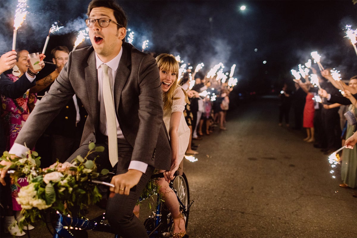 Bride and groom making final exit on a bicycle
