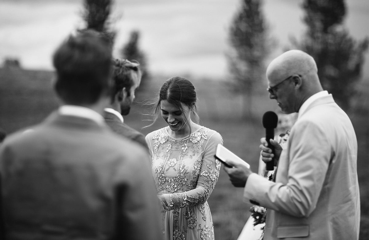 Bride laughing as wedding officiant says something funny