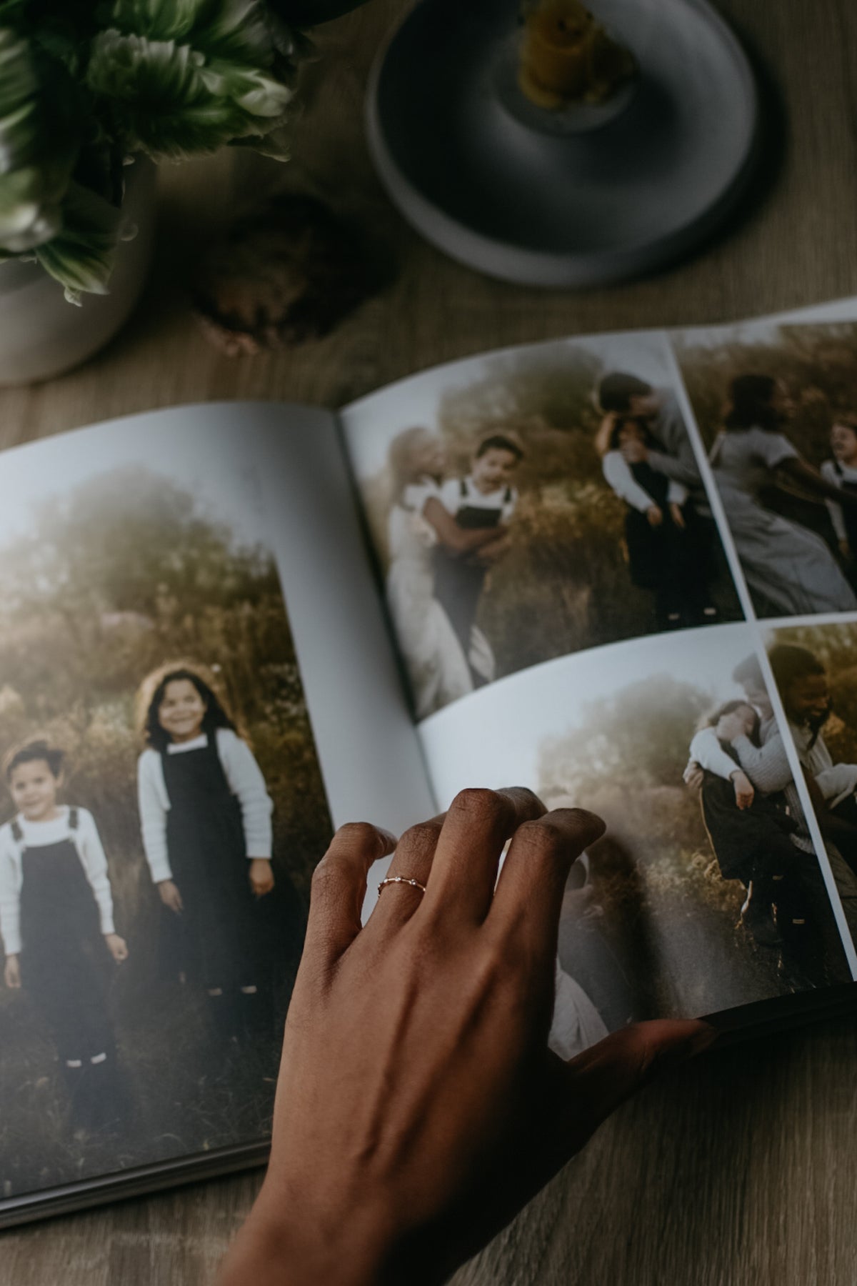 Mother's hand flipping through album filled with photos of her children