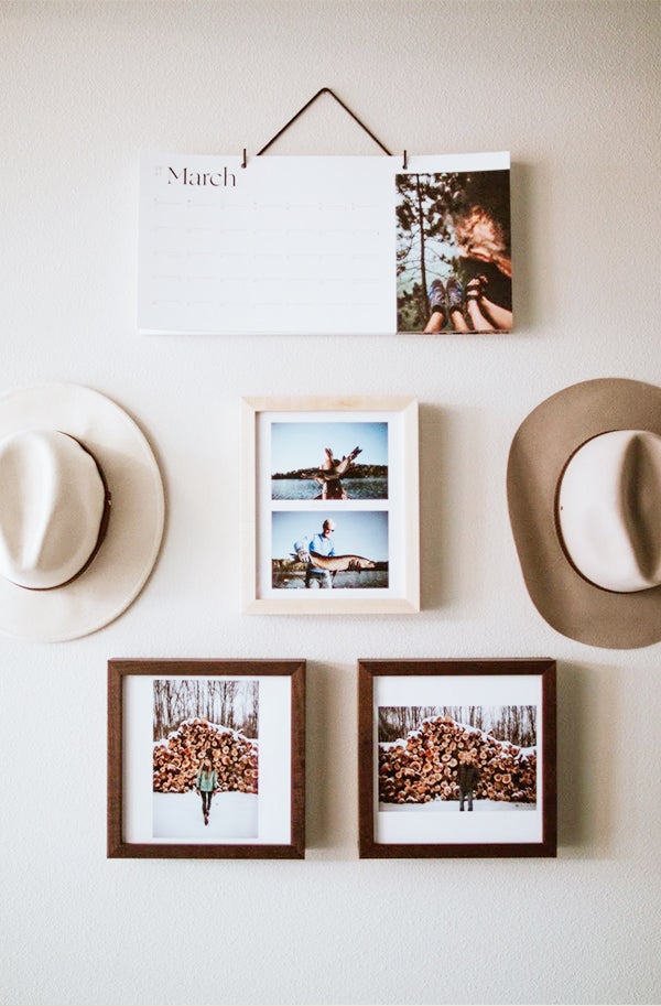 Mix-and-match gallery wall featuring two hats, three framed photos, and an Artifact Uprising Modern Wall Calendar