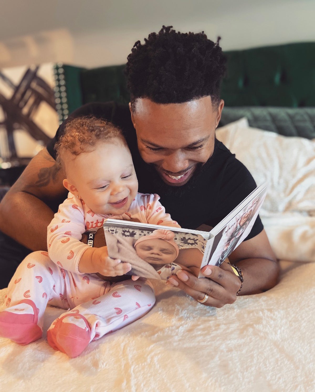 Father and baby daughter reading Artifact Uprising Board Book together on bed