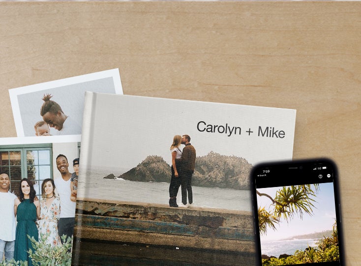 Artifact Uprising photo prints and photo book featuring family photos on table next to iphone