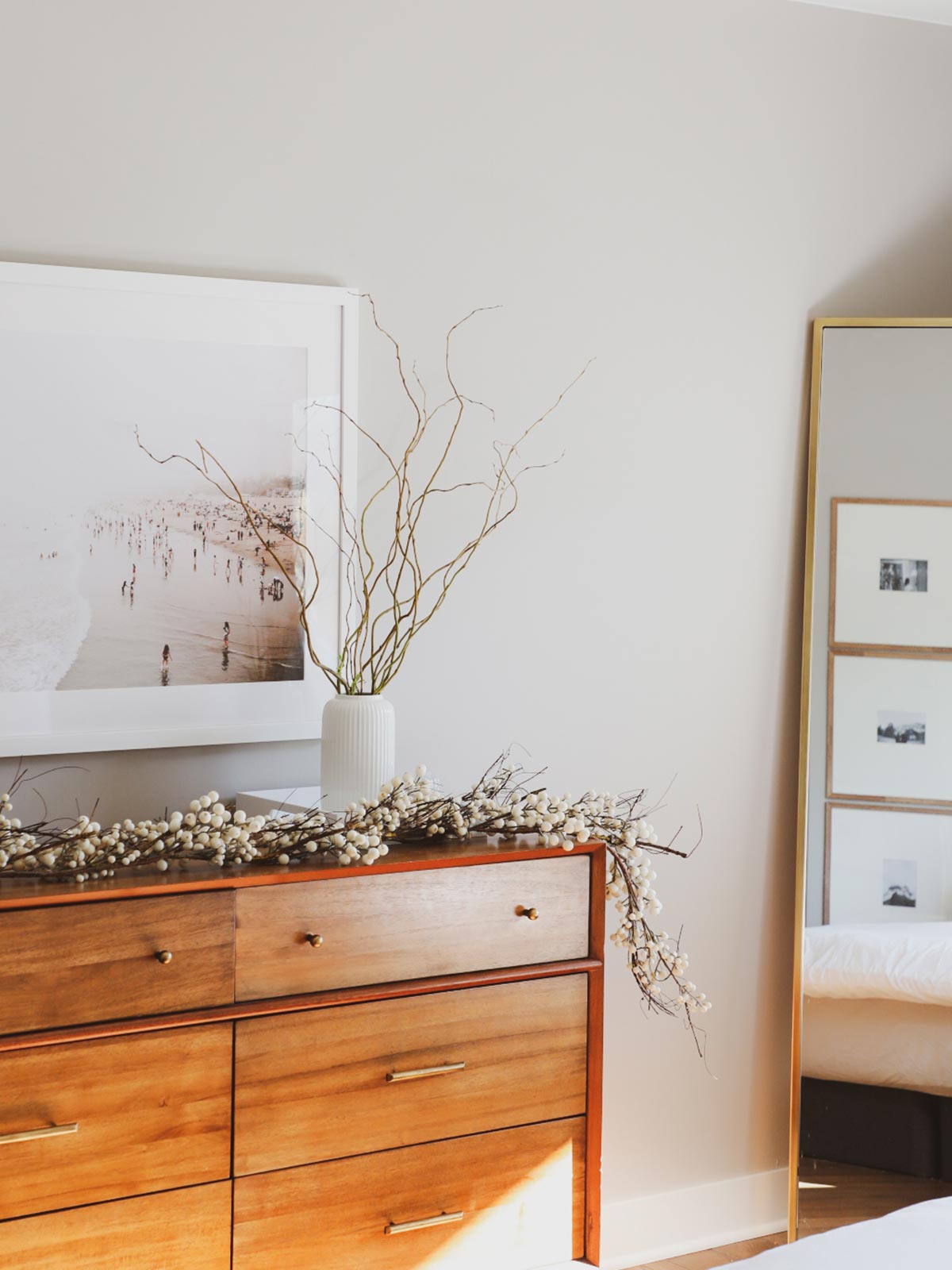 Gallery Frame featuring photo of the beach on bedroom wall above dresser with dried branches in vase.