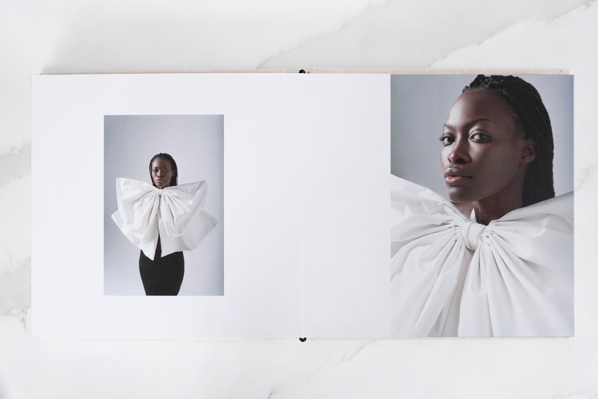 Artifact Uprising Layflat Photo Portfolio Book opened to mid-motion portrait of woman in platform heels flipping hair back