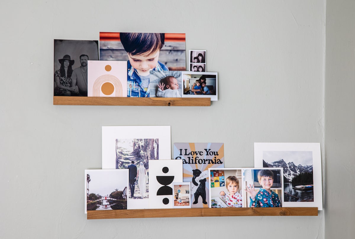 Two Artifact Uprising Wooden Photo Ledges filled with Everyday Prints and other family photos and art prints