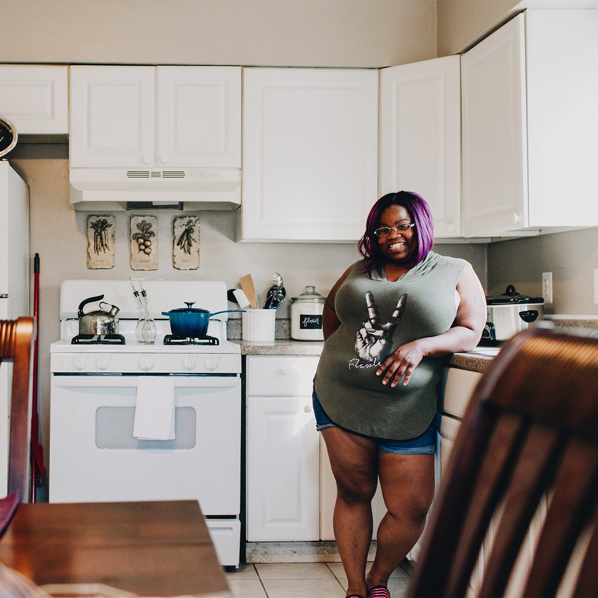 woman standing proudly in her newly furnished kitchen