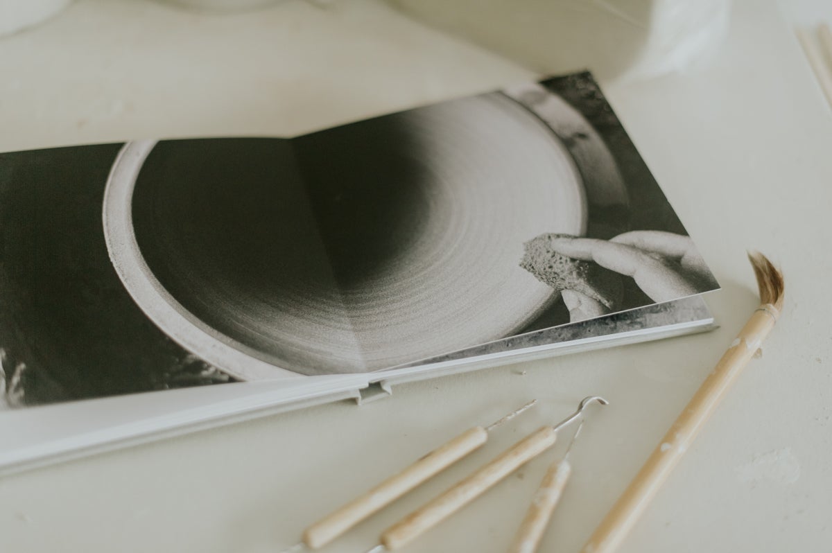 Open photo book next to pottery tools