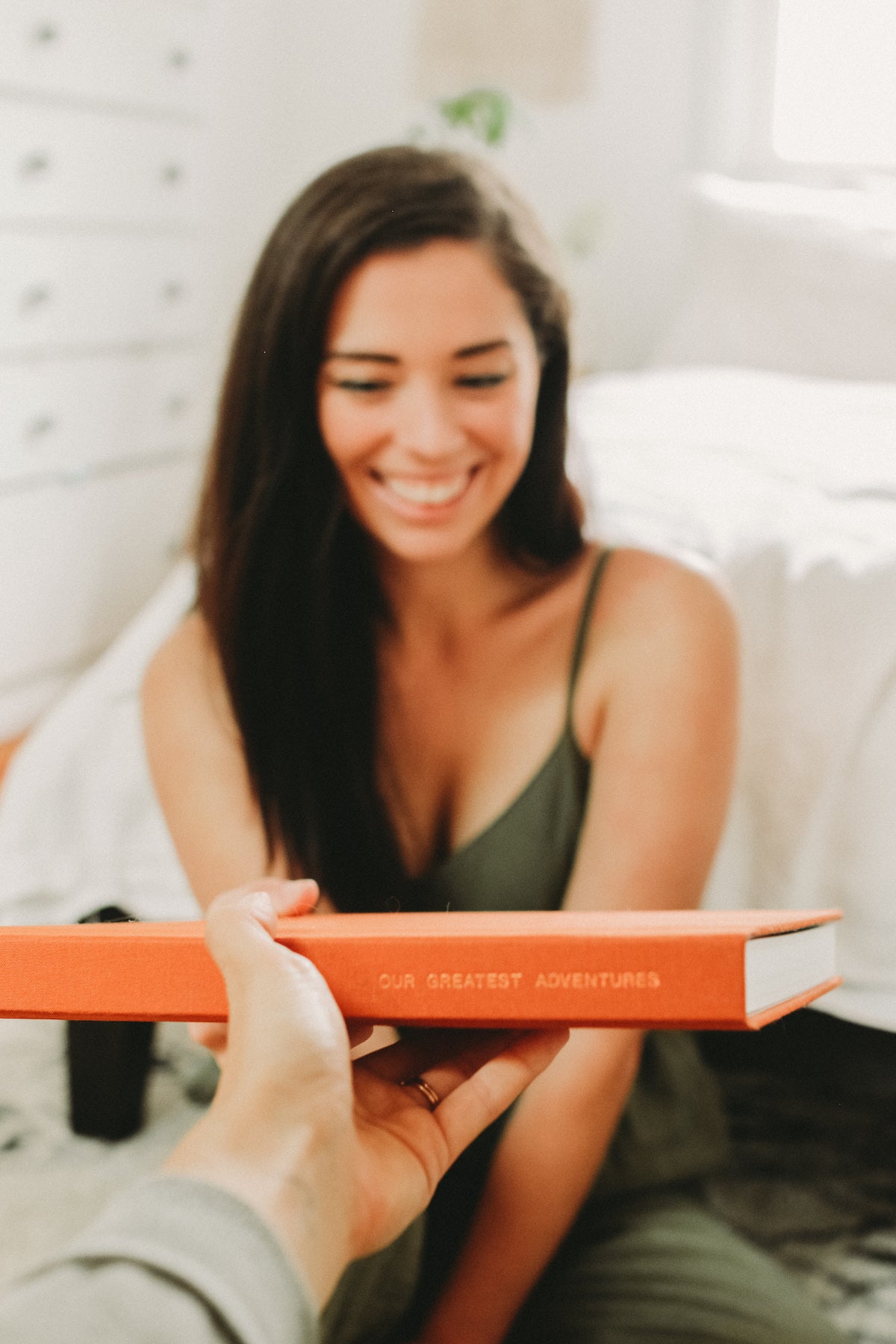 First-person perspective of handing a photo book to a woman