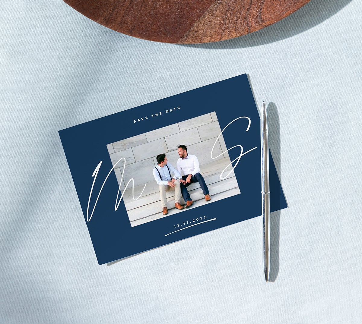 Silver pen resting on top of Artifact Uprising Scripted Initials Save the Date Card