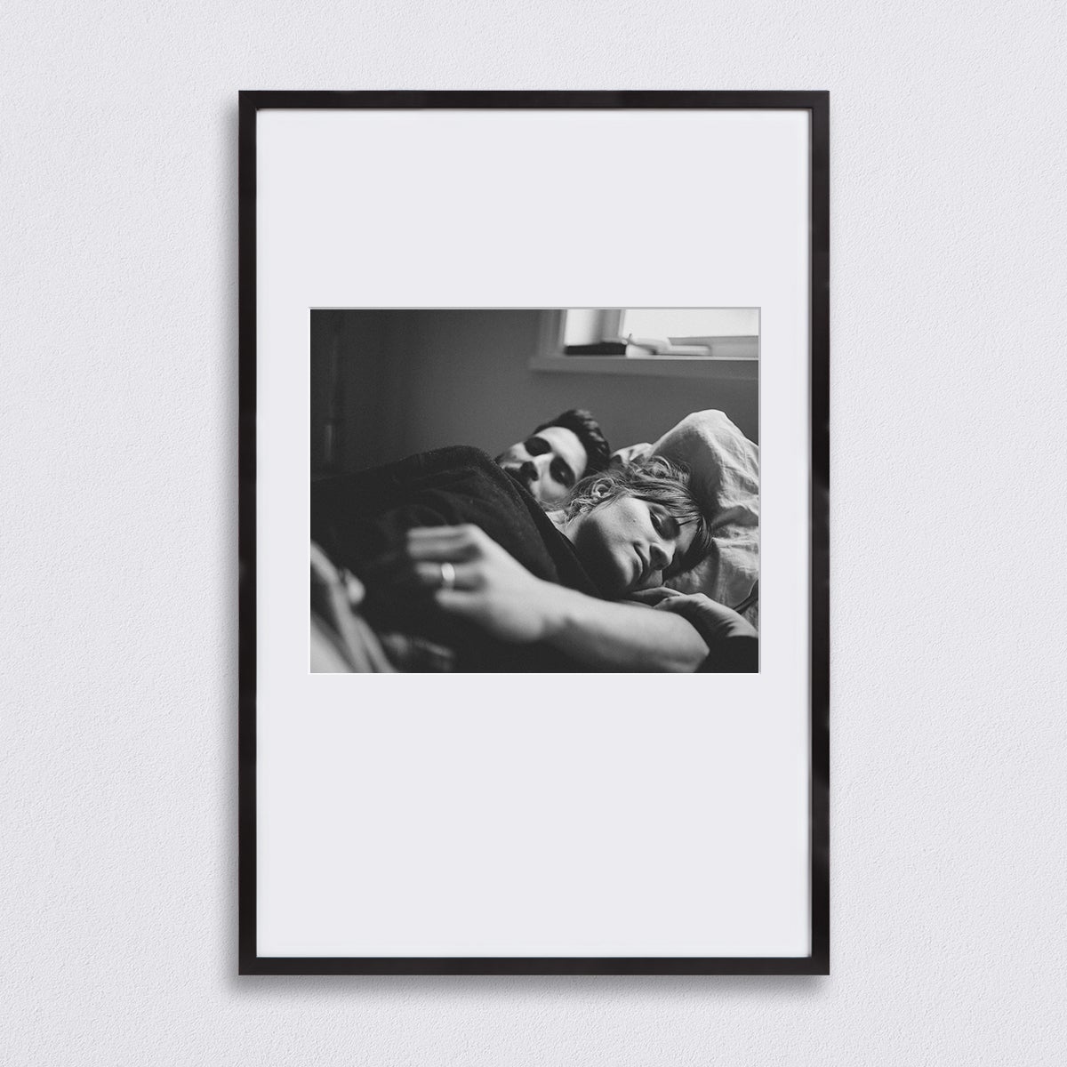 Black and white selfie of couple laying in bed matted to 16 x 13 inch inside of a Black 20 x 30 inch Artifact Uprising Gallery Frame