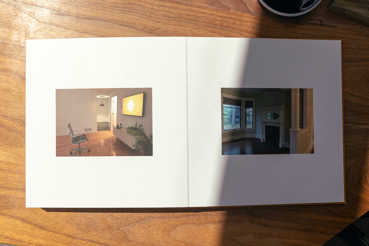 Artifact Uprising Layflat Photo Album opened to photos of empty house