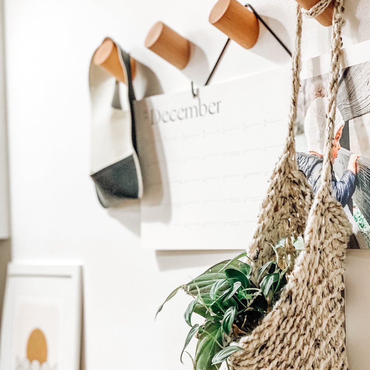 A textured basket filled with greenery and a wall calendar hung on the wall.