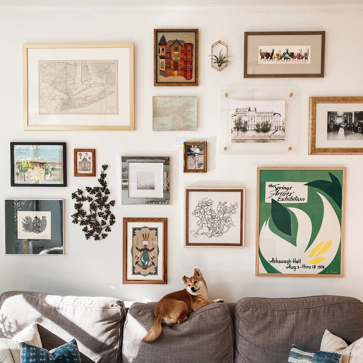 A wall above a couch filled with many different types of frames, materials, colors, etc.