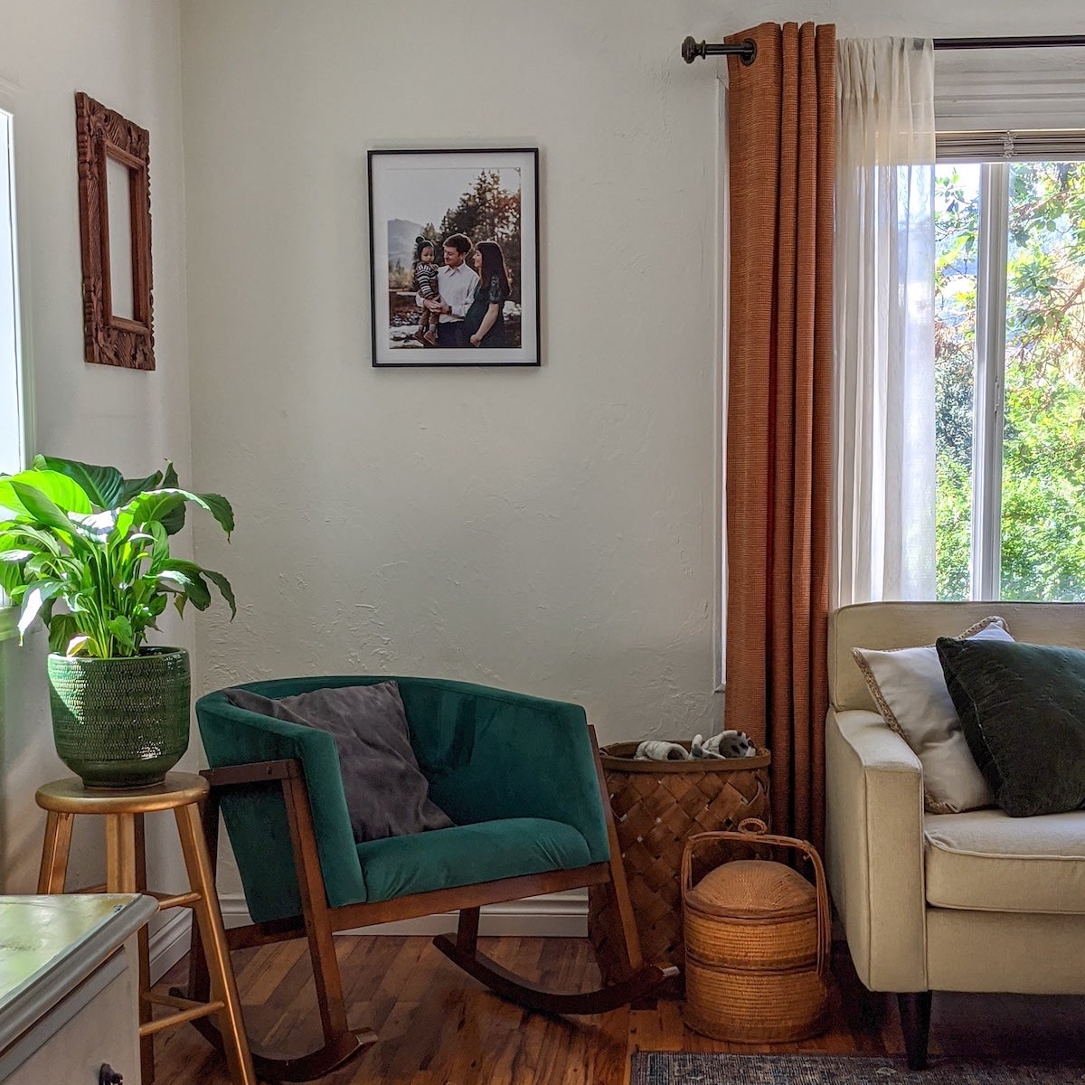 Corner of a living room with an accent chair, plant, and a photo frame on the wall.