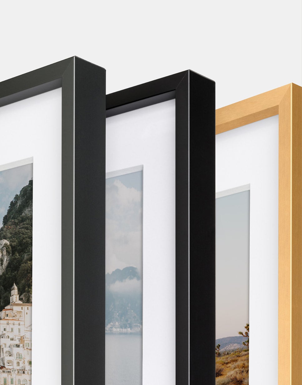 Close up corner shot of three Modern Metal Frames in graphite, black, and brass.