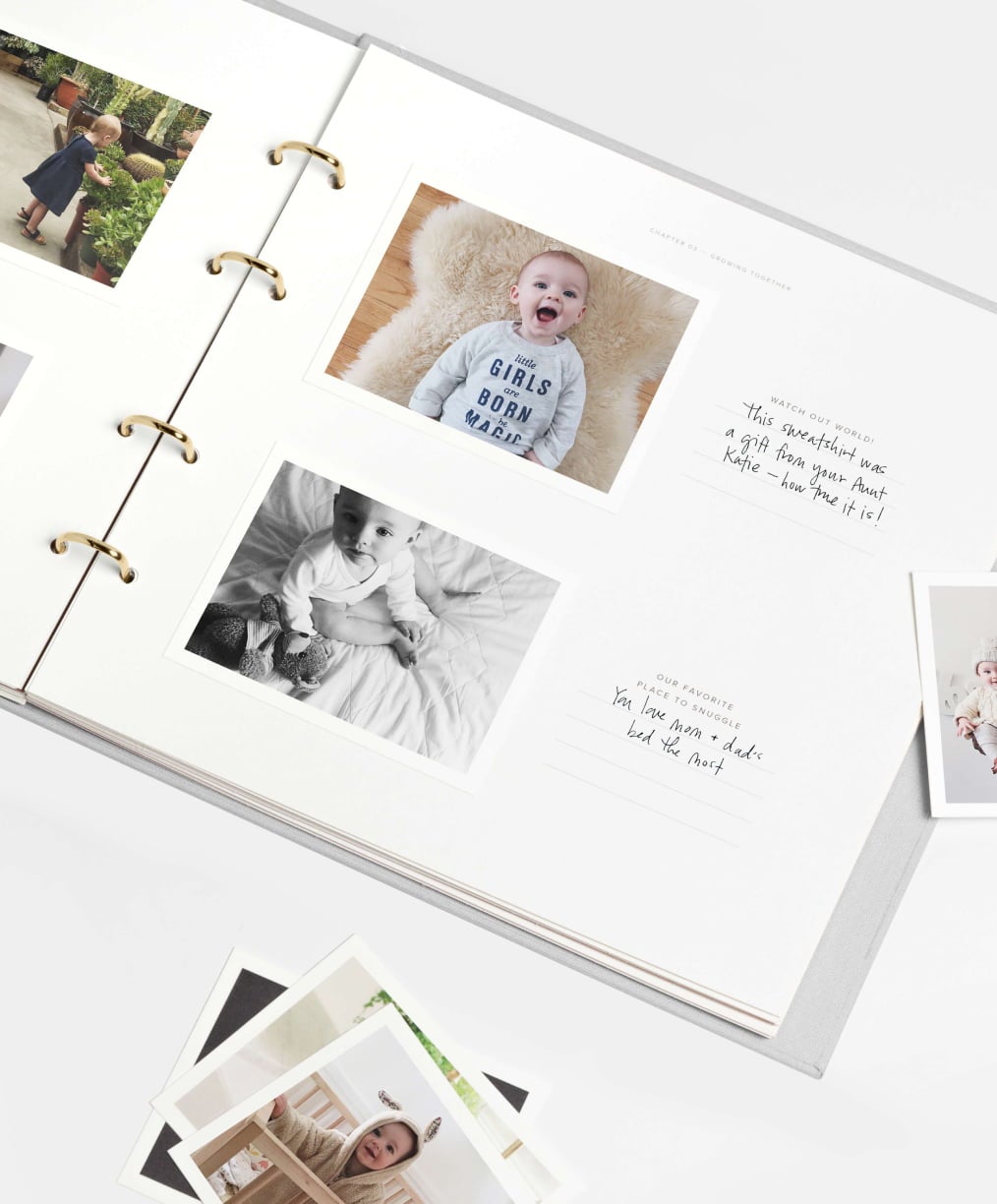 Open baby scrapbook with photos of baby and handwritten notes