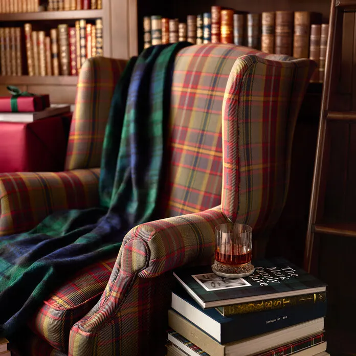 Plaid armchair beside a stack of Artifact Uprising photo books