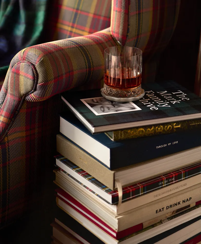Photo books stacked beside a plaid armchair