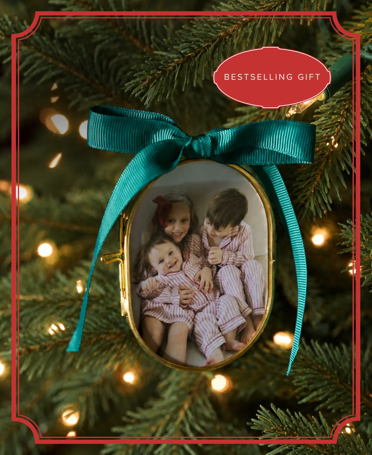 A pressed glass photo ornament with a green ribbon hanging on a Christmas tree