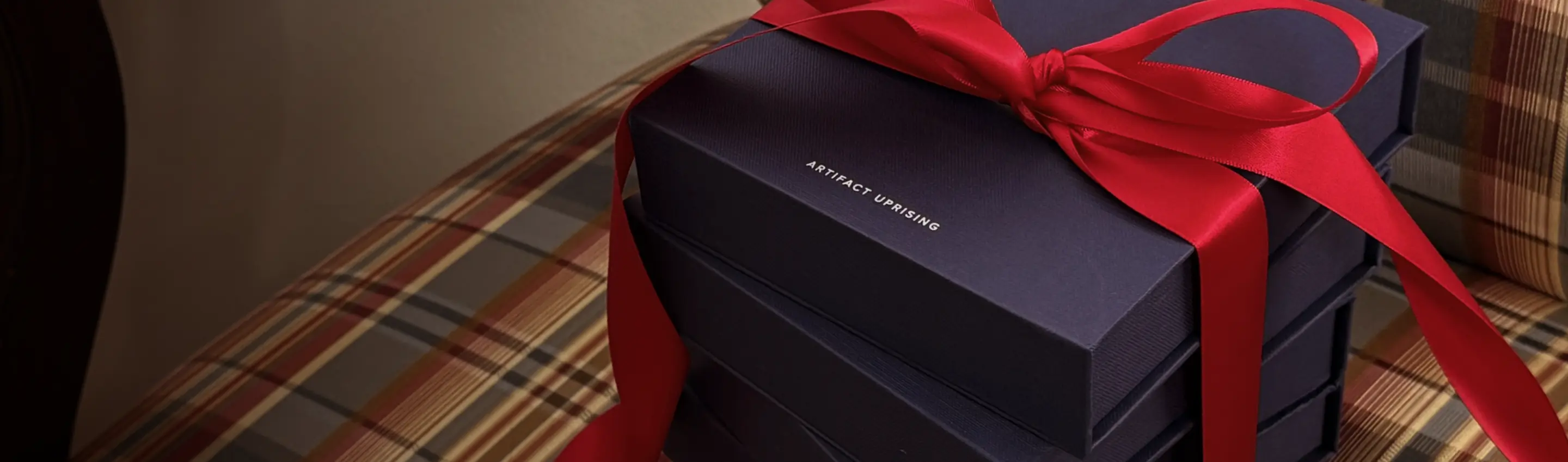 An ornament gift box wrapped with a navy ribbon