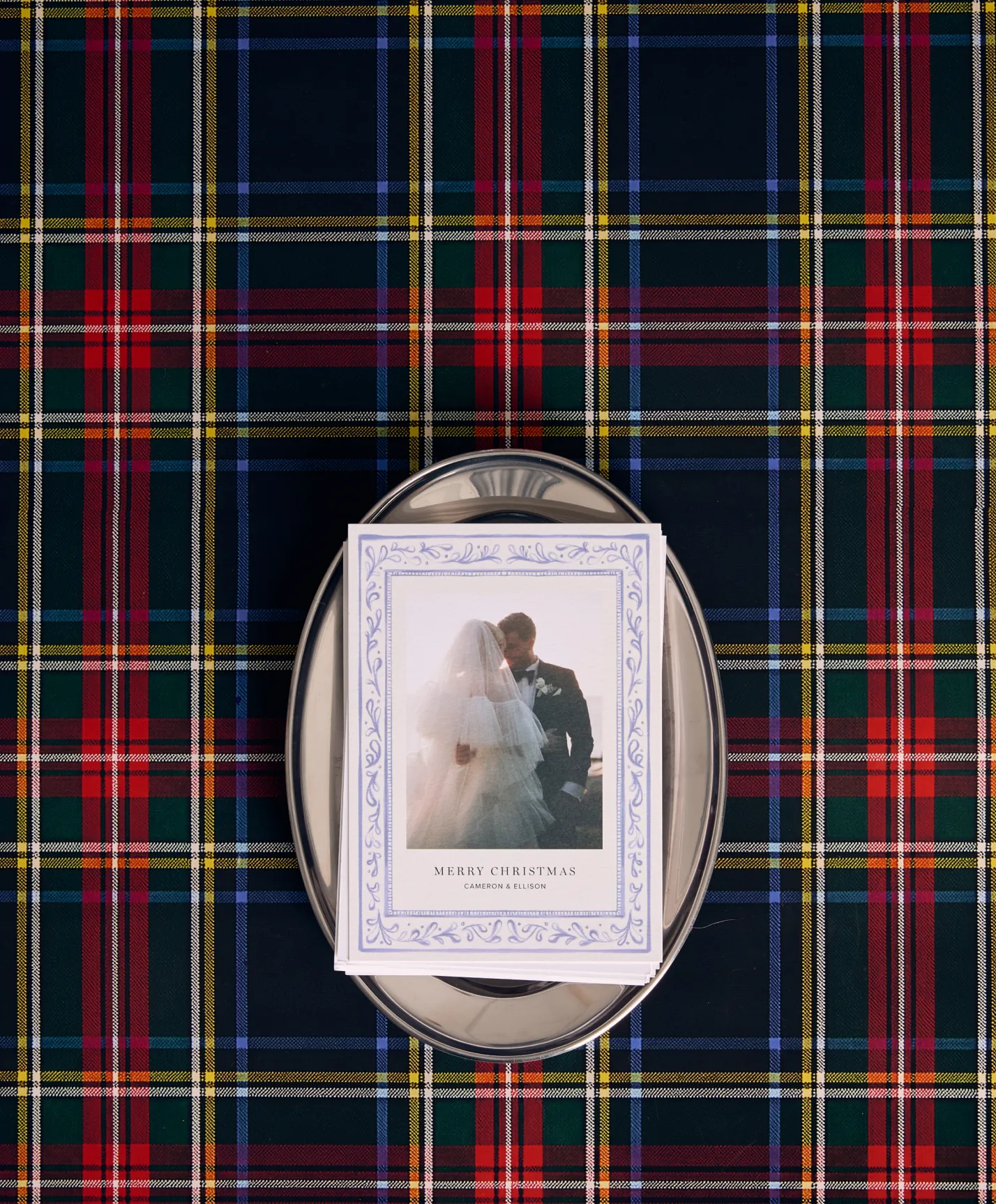 Personalized wedding holiday card on a silver tray over festive plaid