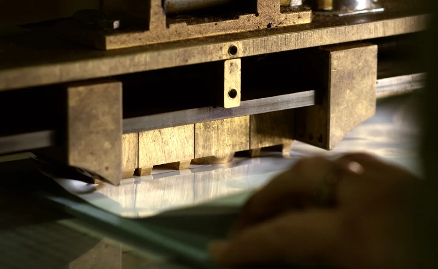 A traditional press stamps the details of a photo album