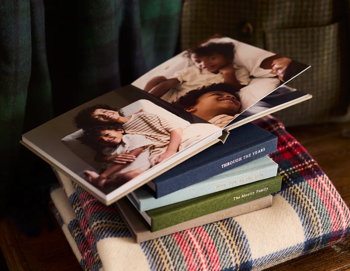 Photo books stacked on a plaid blanket