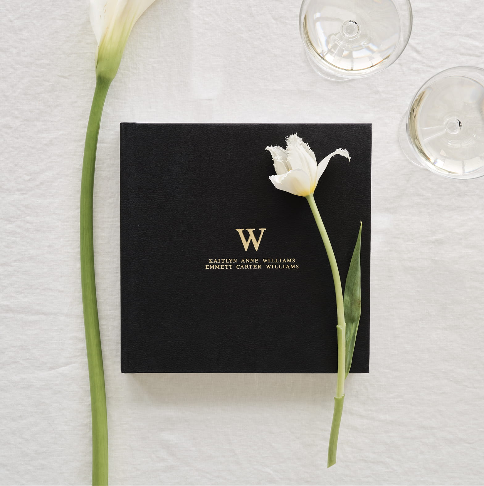 Black Monogram wedding album styled with white flowers