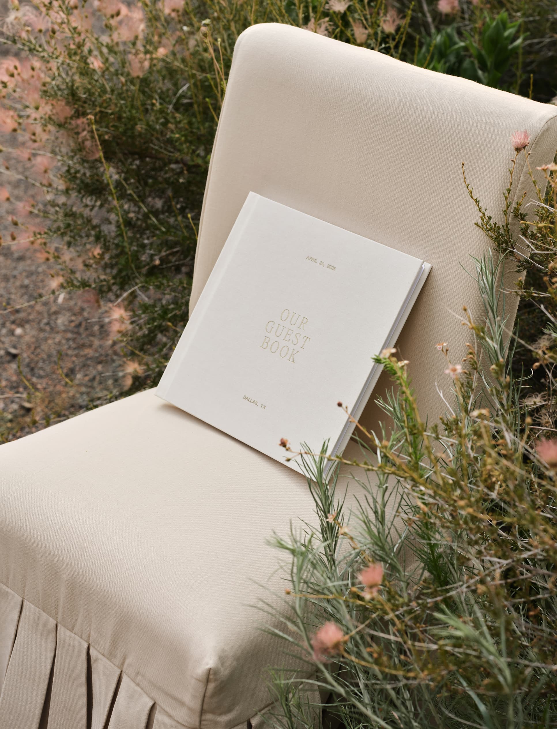 Wedding guest book displayed on a chair among flowers