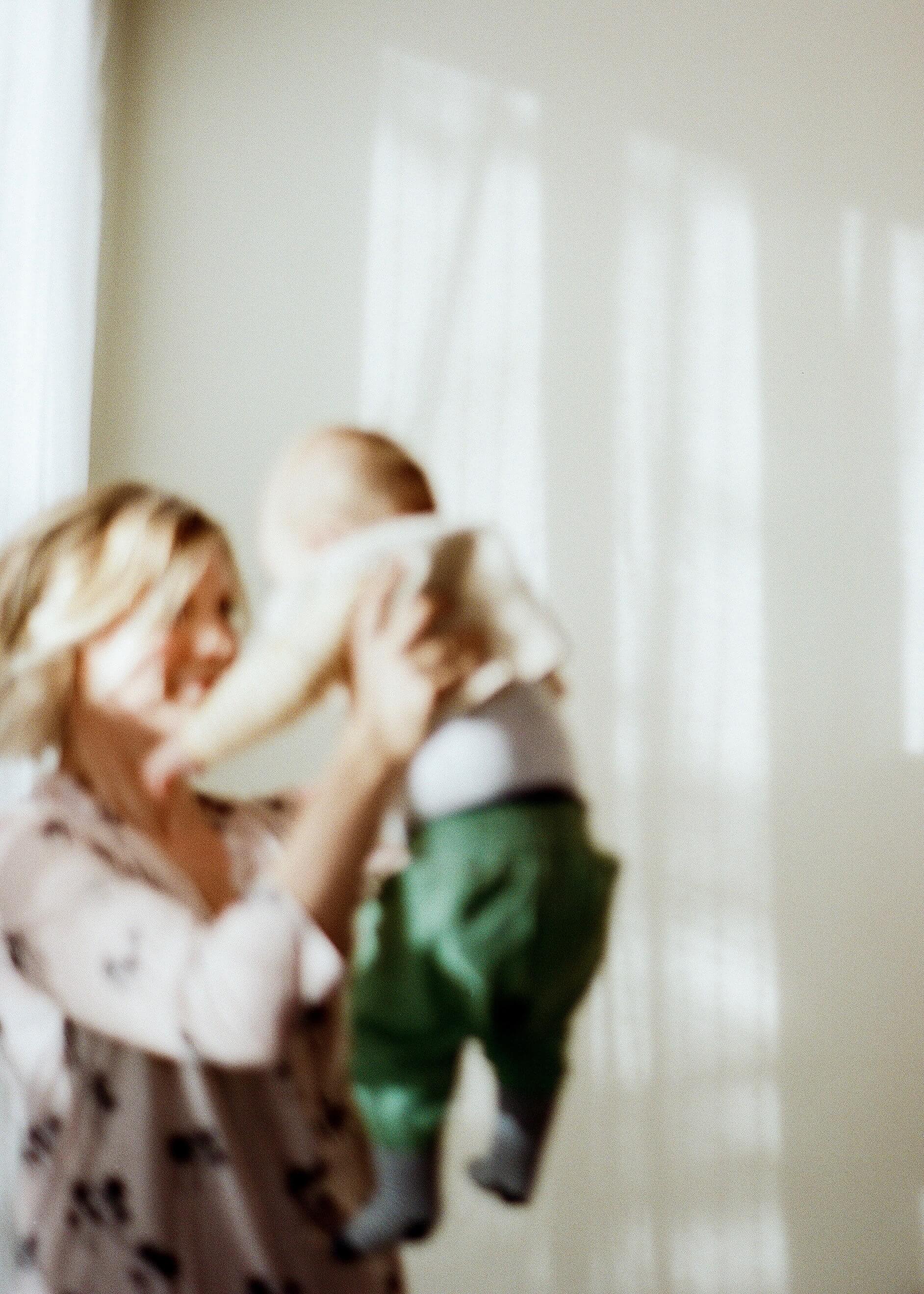 Blurred photo of mother holding up baby