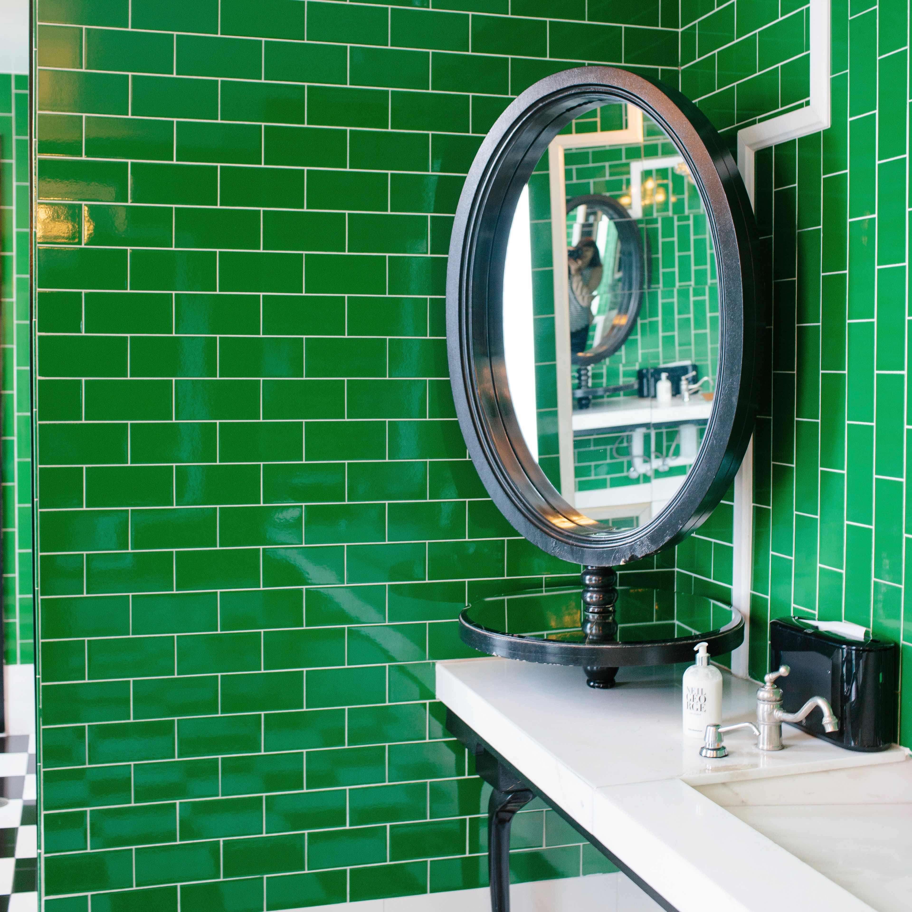 Green tile lines the walls of a washroom at the Viceroy