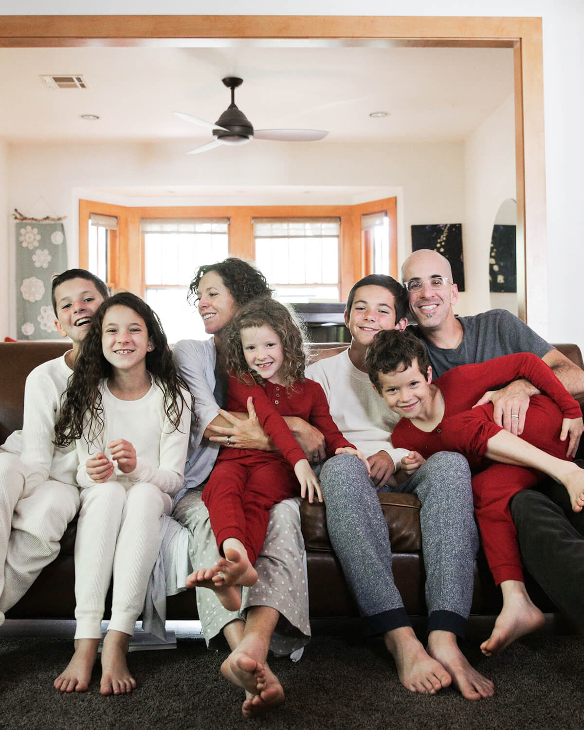 Parents and six children gathered on the couch for a photo on Christmas morning