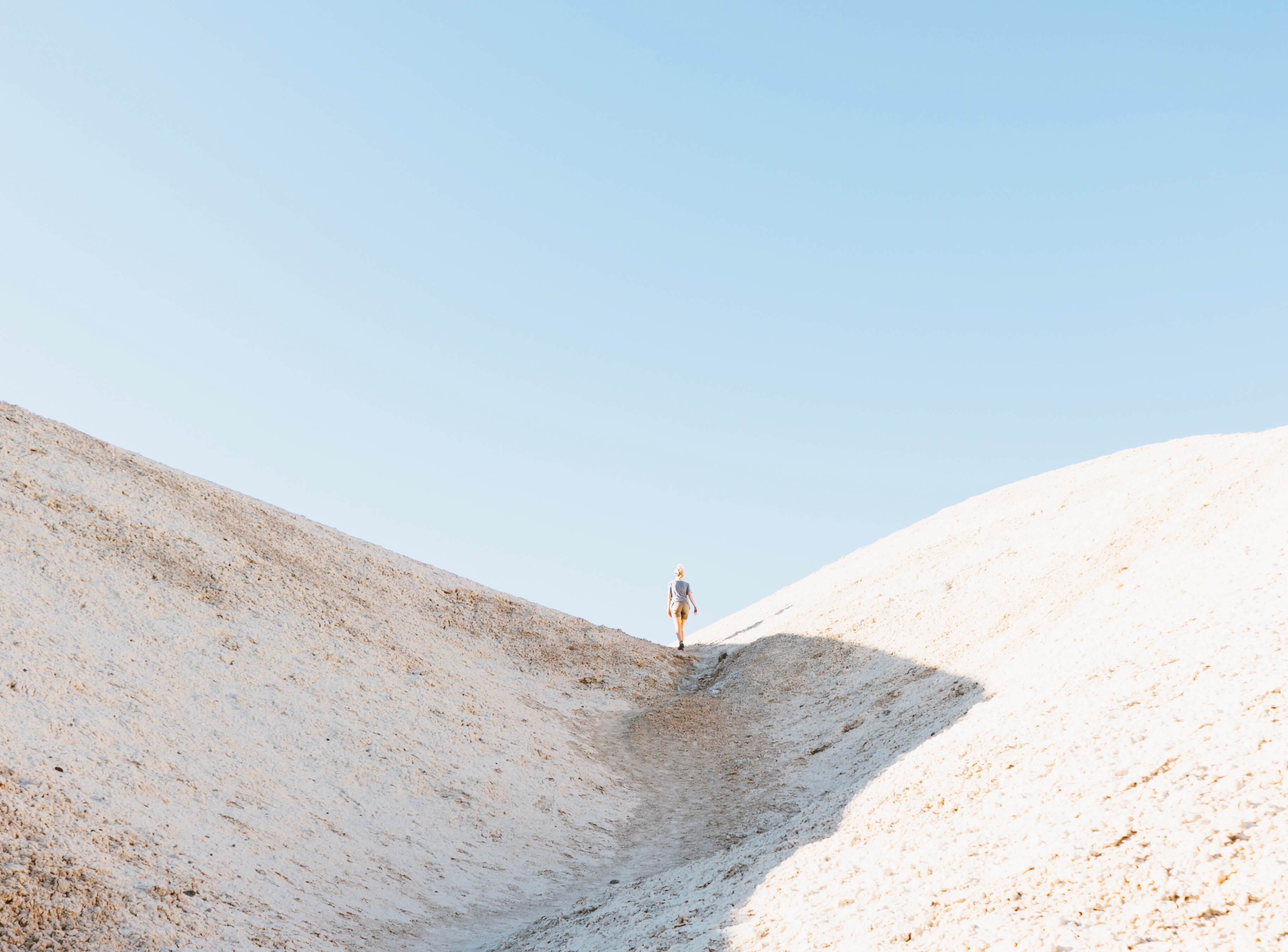 Someone climbing a hill in an arid landscape