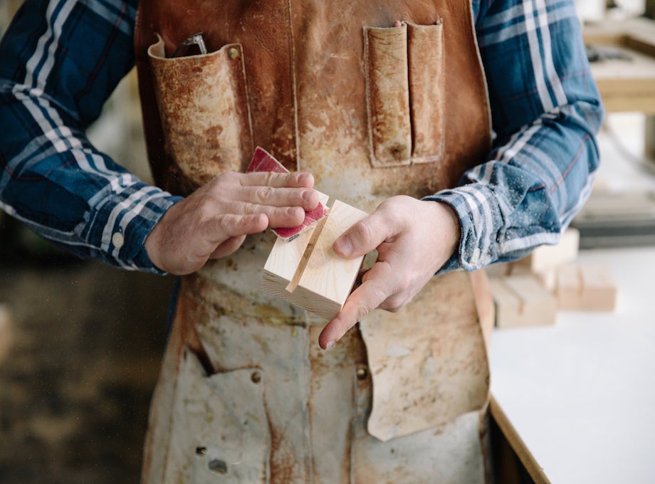 Woodworker hand sanding a wooden print block